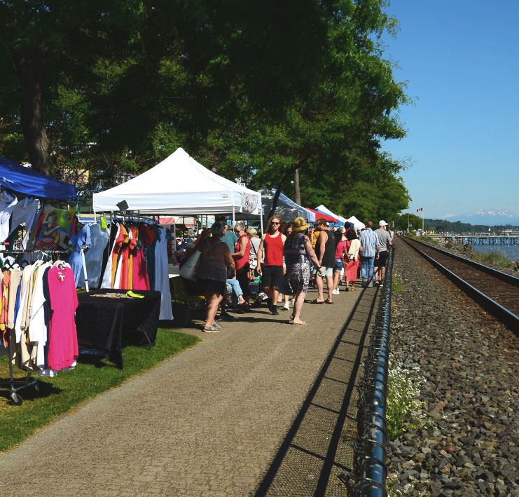 vendor booths along outdoor walkway beside waterfront