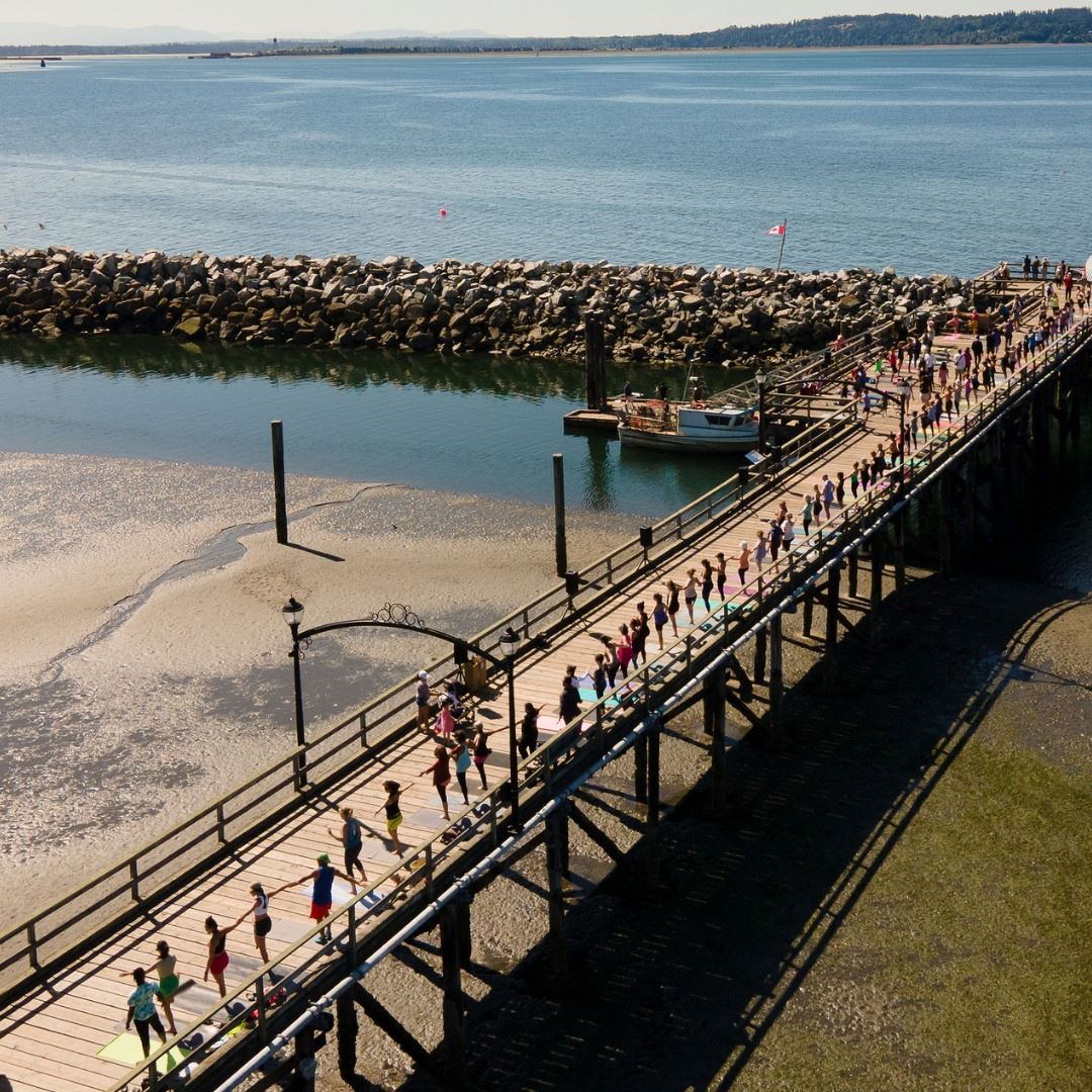 Aerial photo of White Rock Pier with people practicing Yoga.