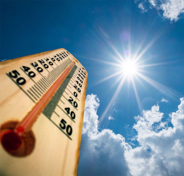 Thermometer at high temperature with beaming sun and blue sky