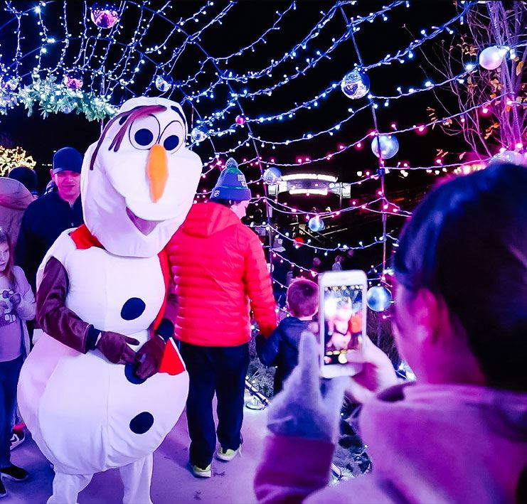 snowman character under Christmas lights