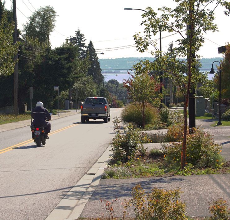 motorcycle and truck driving down hill towards waterfront - transportation survey