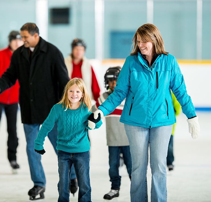 mother and daughter holding hands ice skating