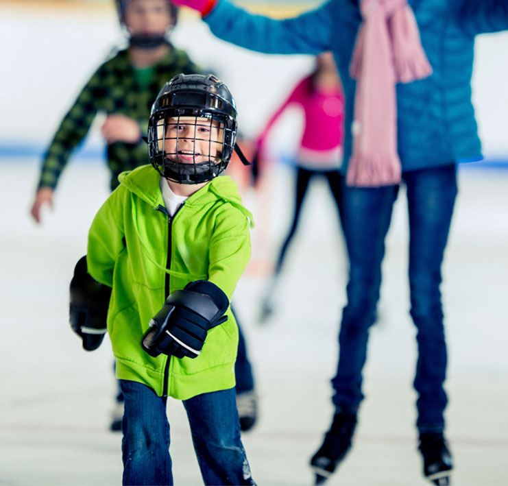 boy wearing helmet ice skating