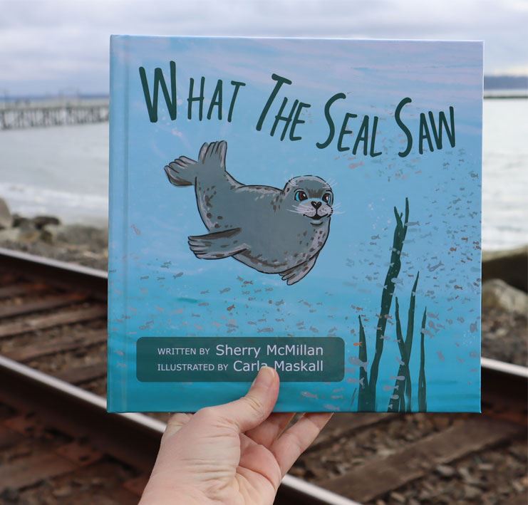 hand holding up a book called "what the seal saw"