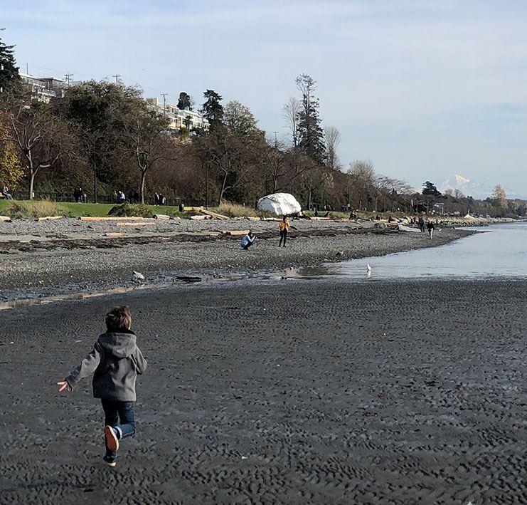 Child running across sandy beach