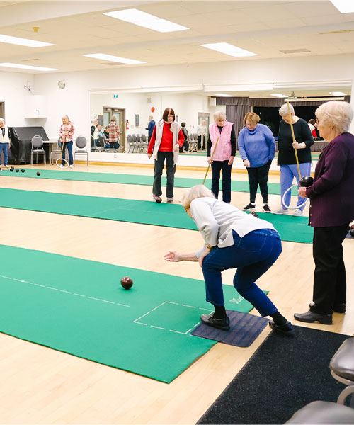 seniors playing indoor carpet bowling