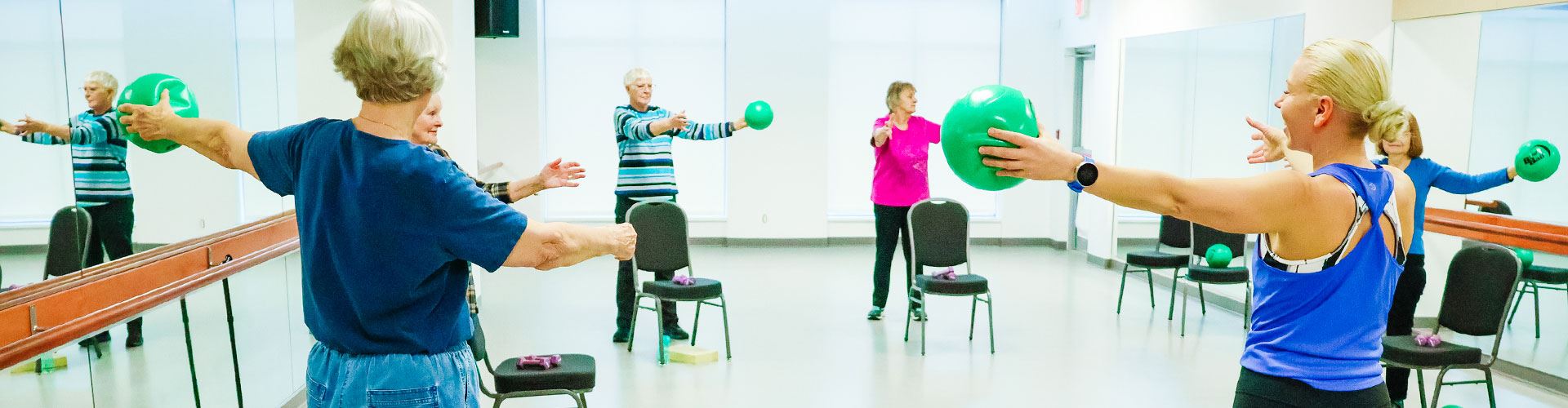 participants in exercise class holding green ball