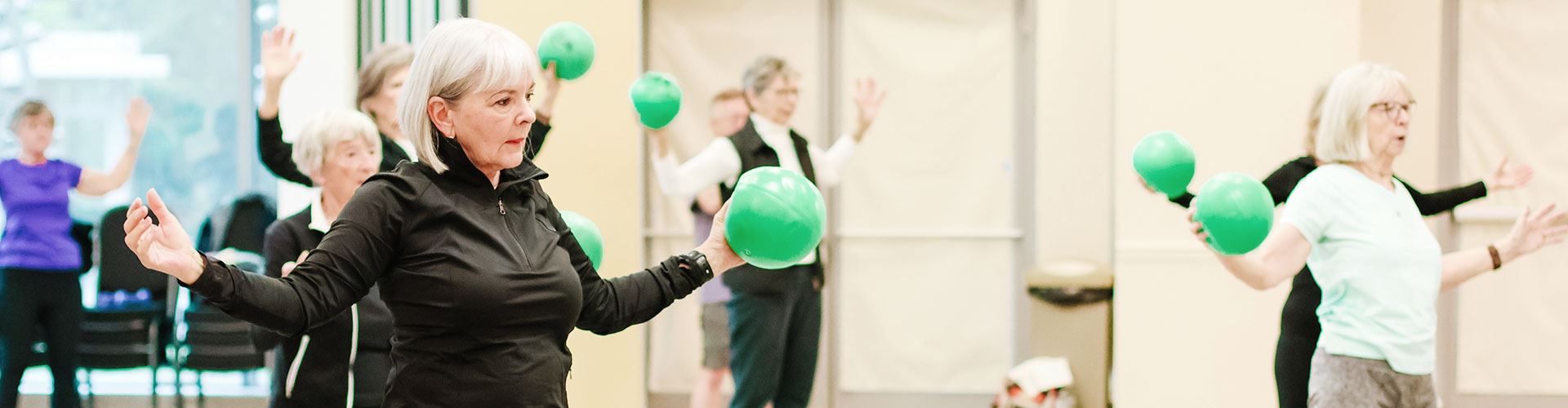 participants in exercise class holding green ball