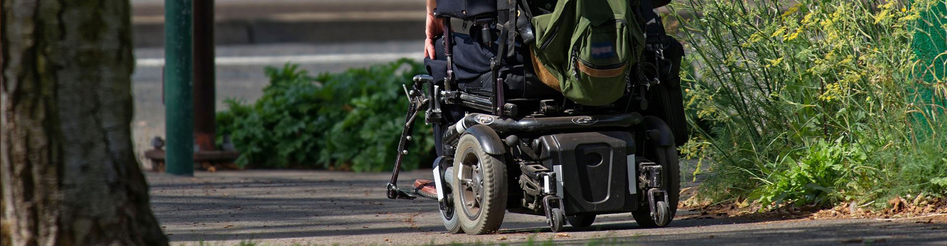 person using motorized wheelchair on sidewalk