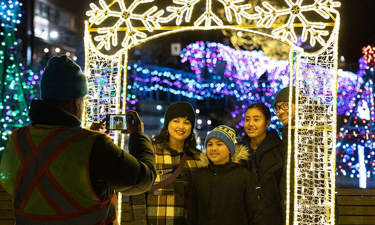 People taking photos with a large lights picture frame