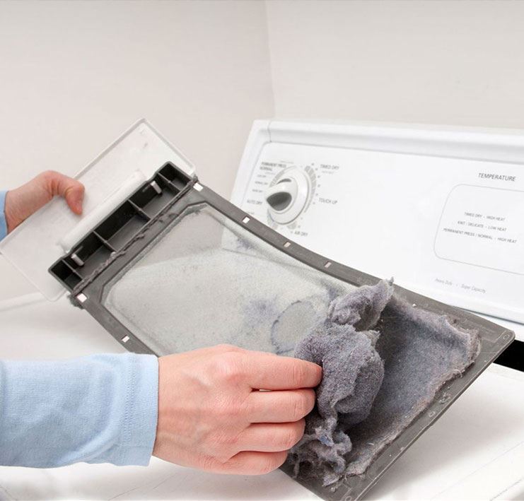 person removing lint from dryer tray
